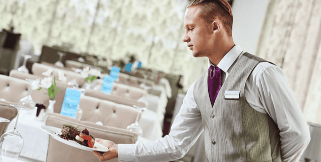 Person serving food in hotel livery