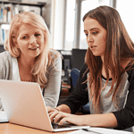 Lecturer helping student on Laptop Computer