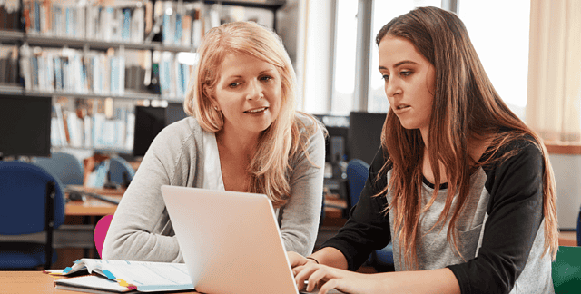 Lecturer helping student on Laptop Computer